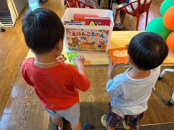 絵本の交換会で、男の子2人が絵本を選んでいる